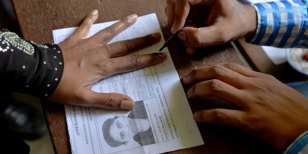 An Indian election official (R) puts indeliable ink on the finger of a voter before she casts her ballot in the Karnataka Legislative Assembly Elections at a polling station in Bangalore on May 12, 2018. - Voting in a key Indian state opened May 12 amid dirty tricks claims by the two leading parties after nearly 10,000 voting cards were seized by election authorities. The opposition Congress party, which has dominated India's politics in the seven decades since independence, is fighting to retain control of its last major state, Karnataka, amid a fierce onslaught by Prime Minister Narendra Modi's ruling Hindu nationalist party. (Photo by MANJUNATH KIRAN / AFP) (Photo credit should read MANJUNATH KIRAN/AFP/Getty Images)
