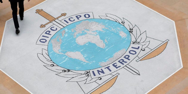 People walk on the Interpol at the international police agency logo in Lyon, central France, Thursday, Nov.8, 2018. (AP Photo/Laurent Cipriani)