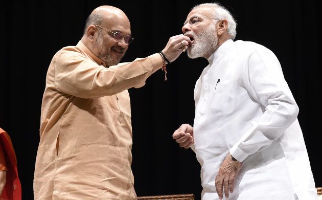 BJP President Amit Shah offers sweets to Prime Minister Narendra Modi during BJP Parliamentary Party meeting on July 31, 2018 in New Delhi.