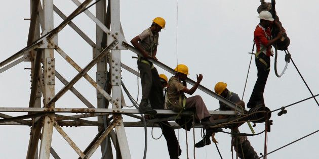 Linemen set up high tension power lines on the outskirts of Ahmedabad.