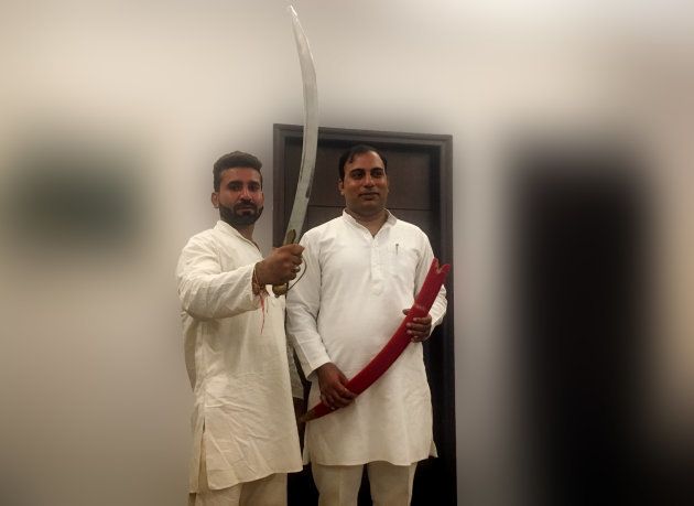 Hariom Sisodia and Amit Jani pose with a sword in Noida on September 26, 2018.