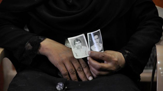 A woman shows picture of her relatives who were killed in the 1987 Hashimpura massacre during a press conference in March 24, 2015 in New Delhi.