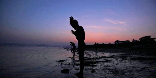 A Hindu holy man offers prayers by the Saryu River on the eve of the anniversary of the Babri mosque demolition in Ayodhya, India, Wednesday, Dec.5, 2012. I