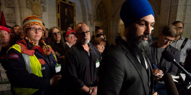 Surrounded by members of Canada Post NDP leader Jagmeet Singh listens to a question from the media about back to work legislation on Nov. 23, 2018 in Ottawa.