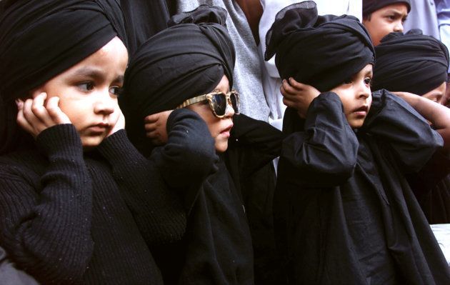 Children from the Muslim religious group 'Raza Academy' cover their ears as a part of a prayer ritual to mark the seventh anniversary of the demolition of the Babri Masjid.