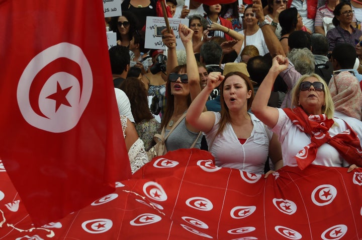 Tunisian women chant slogans and wave their national flags during a demonstration to mark Tunisia's Women's Day on Aug. 13, 2018.