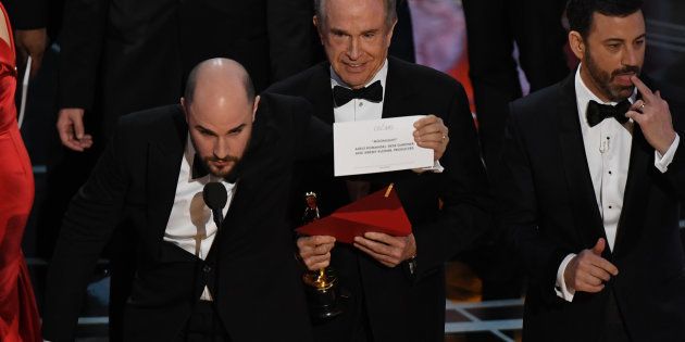 US actor Warren Beatty (C) shows the card reading Best Film 'Moonlight' after mistakingly reading 'La La Land' initially at the 89th Oscars on February 26, 2017 in Hollywood, California. / AFP / Mark RALSTON (Photo credit should read MARK RALSTON/AFP/Getty Images)