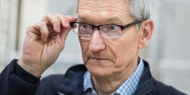 Apple CEO Tim Cook looks at a table during a visit of the shopfitting company Dula that delivers tables for Apple stores worldwide in Vreden, western Germany, on February 7, 2017. / AFP / dpa / Bernd Thissen / Germany OUT (Photo credit should read BERND THISSEN/AFP/Getty Images)