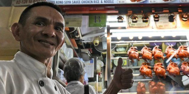 Singaporean chef Chan Hon Meng poses infront of his Hong Kong Soya Sauce Chicken Rice and Noodle stall in Singapore on July 22, 2016.