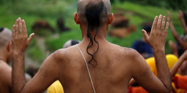 A Hindu priest wearing a sacred thread performs a ritual during the Janai Purnima festival (Sacred Thread Festival) at Pashupatinath Temple in Kathmandu, Nepal, August 18, 2016. Hindus take holy baths and change their sacred thread, also known as Janai, for protection and purification, during the festival. REUTERS/Navesh Chitrakar