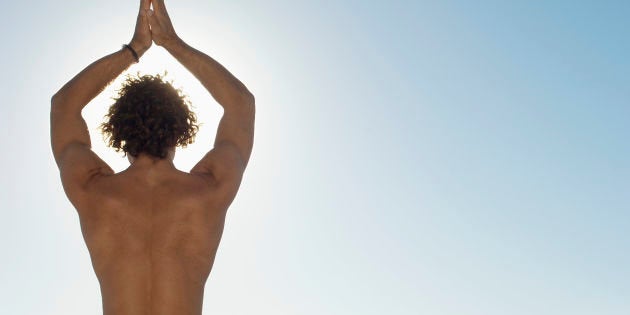 Young man doing yoga (rear view)