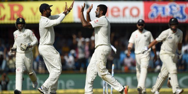 India's bowler Ravichandran Ashwin (C) celebrates with teammate Cheteshwar Pujara after taking the wicket of New Zealand batsman Ross Taylor during the fourth day of third Test cricket match between India and New Zealand at The Holkar Cricket Stadium in Indore on October 11, 2016.