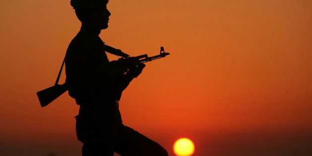 An Indian policeman is silhouetted against the setting sun as he stands guard on the banks of river Tawi ahead of India's Republic Day celebrations in Jammu January 23, 2012.