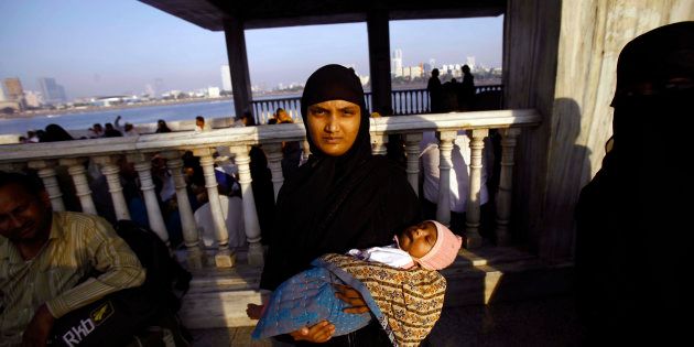 A Muslim woman holds her child and stands at the Haji Ali Dargah in Mumbai, India, Thursday, Nov. 8, 2012.