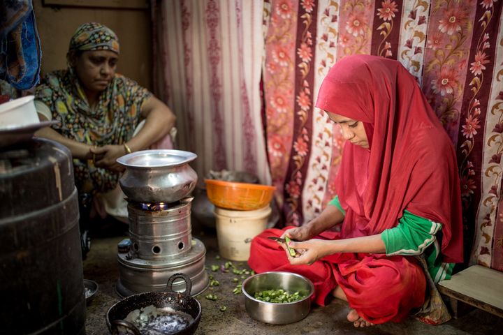 Ayesha in her home in Kolkata helps her mother with the chores of the house. "She will fulfill my dreams," her mother said.