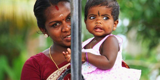 Portrait of young indian mother with a baby girl wearing traditional make-up on their foreheads at Alleppey on December 27, 2009 in Alapuzha (Alleppey) near Trivandrum, Kerala, India.