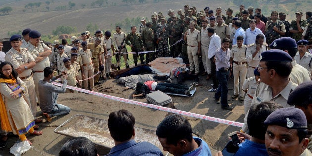 Police officers and Special Task Force soldiers stand beside dead bodies of the suspected members of the banned Students Islamic Movement of India (SIMI), who earlier today escaped the high security jail in Bhopal, and later got killed in an encounter at the Acharpura village on the outskirts of Bhopal, India, October 31, 2016. REUTERS/Raj Patidar