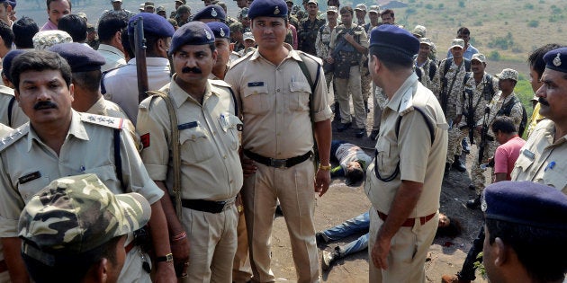 Police officers and Special Task Force soldiers stand beside dead bodies of the suspected members of the banned Students Islamic Movement of India (SIMI), who earlier today escaped the high security jail in Bhopal, and later got killed in an encounter at the Acharpura village on the outskirts of Bhopal, India, October 31, 2016. REUTERS/Raj Patidar