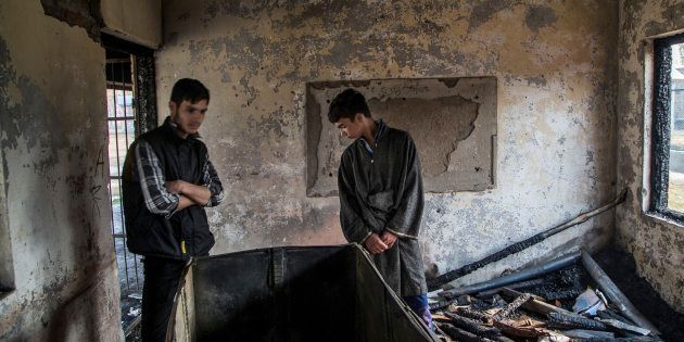 Students inspect the damage of a partially burned government high school in Goripora, on the outskirts of Srinagar.