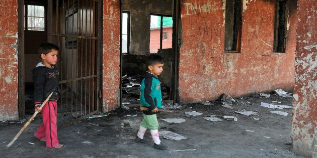 Small children play at the burnt building of government school at Gori Pora on October 31, 2016 in Srinagar, India.