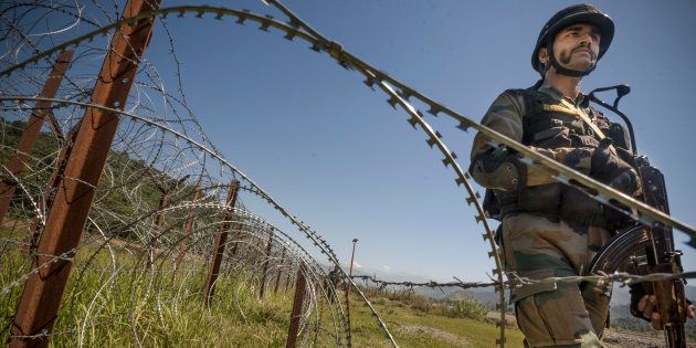 An Indian Army soldier patrols on the fence near the India-Pakistan LOC.