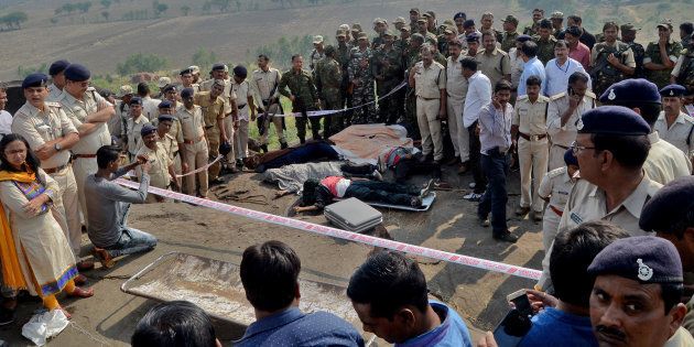 Police officers and Special Task Force soldiers stand beside dead bodies of the suspected members of the banned Students Islamic Movement of India (SIMI), who escaped the high security jail in Bhopal, and later got killed in an encounter on the outskirts of Bhopal on 31 October 2016.