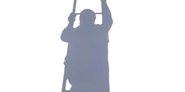 Shadow of worker climbing on ladder isolated on white background.