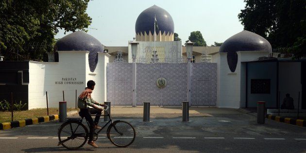 An Indian cyclist rides past the entrance to the Pakistan High Commission in New Delhi.