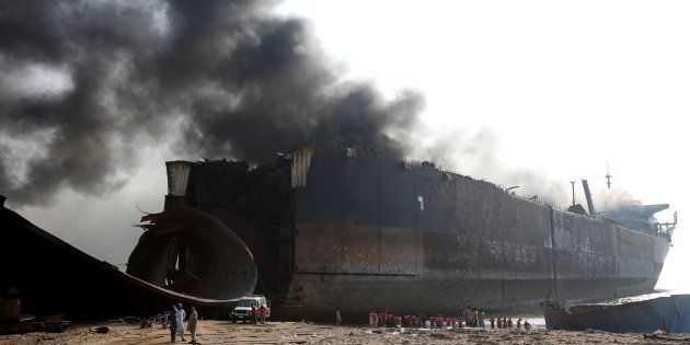 Rescue workers gather near the burning oil tanker at the ship-breaking yard in Gaddani, Pakistan, November 2, 2016.