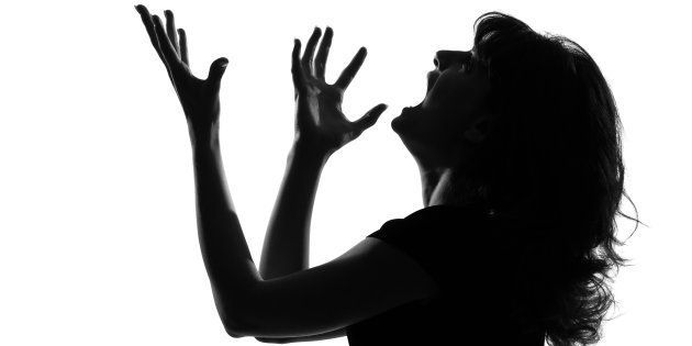 Portrait silhouette of a young woman screaming in anger.
