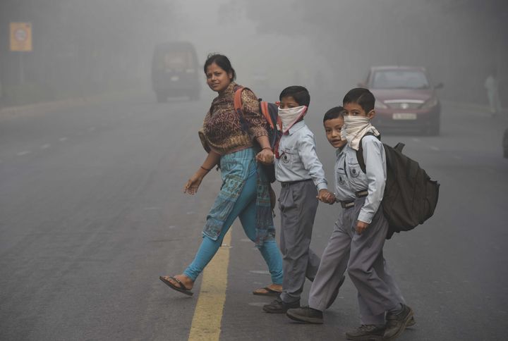 School children battling the haze of contaminated air early in the morning on their way to school.