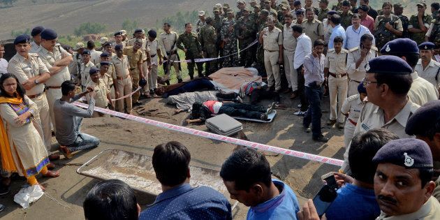 Police officers and Special Task Force soldiers stand beside dead bodies of the suspected members of the banned Students Islamic Movement of India (SIMI), who earlier today escaped the high security jail in Bhopal, and later got killed in an encounter at the Acharpura village on the outskirts of Bhopal, India, October 31, 2016.