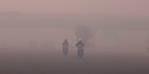 Commuters make their way amidst the heavy smog in New Delhi, India, October 31, 2016.