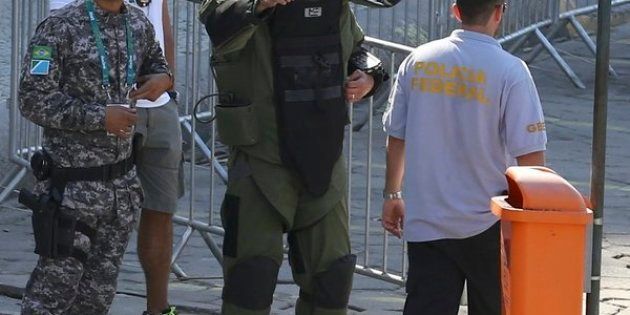An agent of the bomb squad in protective clothing stands in the area near the finishing line of the men's cycling road race at the 2016 Rio Olympics after they made a controlled explosion, in Copacabana, Rio de Janeiro, Brazil August 6, 2016.