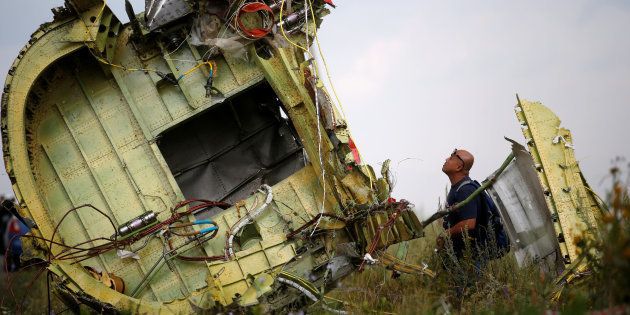 A Malaysian air crash investigator inspects the crash site of Malaysia Airlines Flight MH17, near the village of Hrabove (Grabovo) in Donetsk region, Ukraine, July 22, 2014. REUTERS/Maxim Zmeyev/File Photo TPX IMAGES OF THE DAY