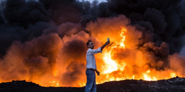 A man takes a selfie in front of oil that has been set ablaze in the Qayyarah area of Iraq, some 35 miles south of Mosul, on Thursday during an Iraqi forces operation against Islamic State militants in the battle for the key city.