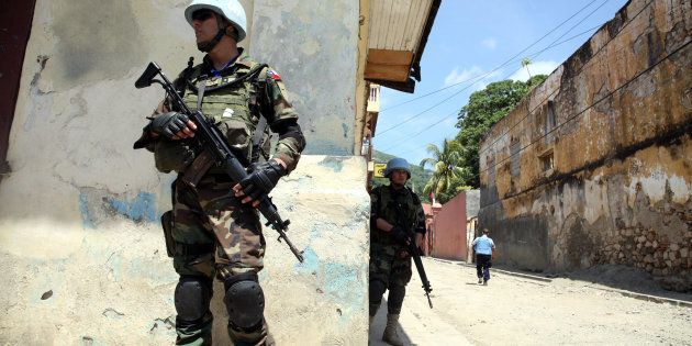 CAP-HAITIEN, HAITI - JULY 30: U.N. Peacekeepers patrol outside a government building that was seized by former soldiers of the Armed Forces of Haiti July 30, 2008 in Cap-Haitien, Haiti. About 200 ex-soldiers, some wearing camouflage and armed, occupied the buildings which were the former army headquarters and prison in the northern city of Cap-Haitien and an army barracks in Ouanaminthe. They are demanding 14 years of back-pay and reinstatement of the country's armed forces which was disbanded in 1995 by ousted president, Jean-Bertrand Aristide. U.N. peacekeepers and Haitian police were dispatched to negotiate a peaceful surrender. (Photo by Daniel Morel/Getty Images)