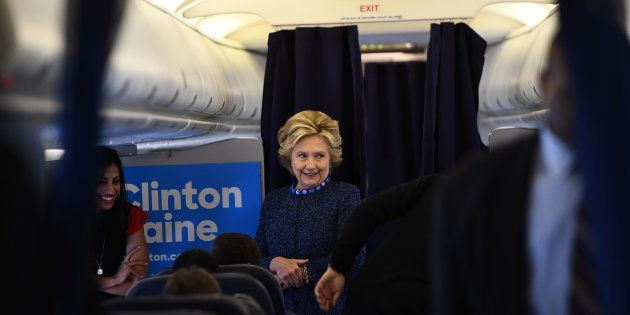 US Democratic presidential nominee Hillary Clinton talks to staff onboard her campaign plane at the Westchester County Airport in White Plains, New York, on October 28, 2016. / AFP / Jewel SAMAD (Photo credit should read JEWEL SAMAD/AFP/Getty Images)