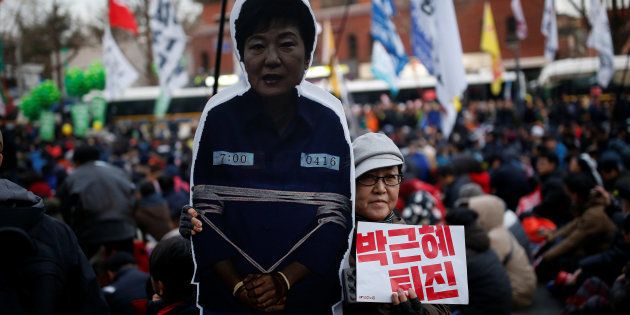 A woman poses for photographs with a cutout of South Korean Park Geun-hye as they march toward the Presidential Blue House during a protest calling for South Korean President Park Geun-hye to step down in central Seoul, South Korea, December 3, 2016. REUTERS/Kim Hong-Ji