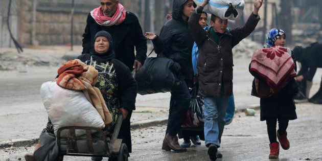 A man pushes a woman on a cart as they flee deeper with others into the remaining rebel-held areas of Aleppo, Syria December 13, 2016. REUTERS/Abdalrhman Ismail
