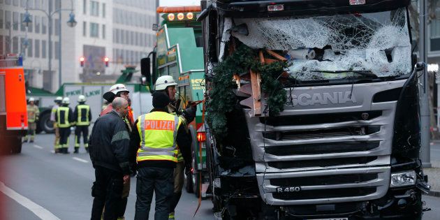Fire fighters stand beside the truck which ploughed last night into a crowded Christmas market in the German capital Berlin, Germany, December 20, 2016. REUTERS/Hannibal Hanschke