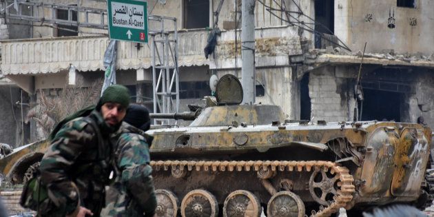 TOPSHOT - Syrian pro-government forces patrol the northern embattled city of Aleppo on December 14, 2016. Shelling and air strikes sent terrified residents running through the streets of Aleppo as a deal to evacuate rebel districts of the city was in danger of falling apart. / AFP / George OURFALIAN (Photo credit should read GEORGE OURFALIAN/AFP/Getty Images)