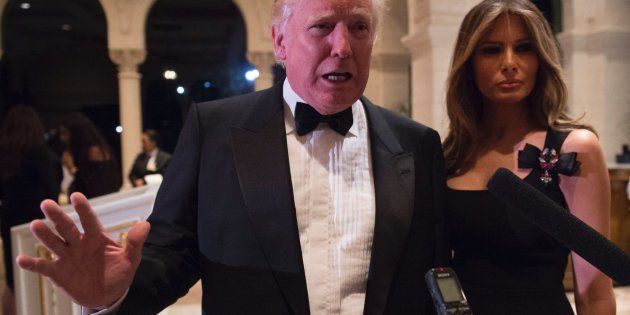 US President-elect Donald Trump answers questions from reporters accompanied by wife Melania for a New Year's Eve party December 31, 2016 at Mar-a-Lago in Palm Beach, Florida. / AFP / DON EMMERT (Photo credit should read DON EMMERT/AFP/Getty Images)