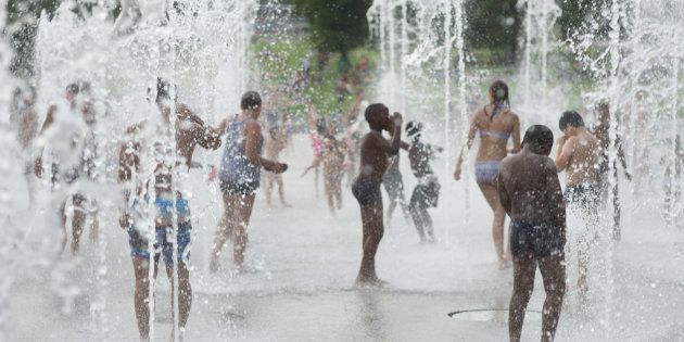 As temperatures soared to 100 degrees Fahrenheit during the Paris heat wave in August 2016, children cooled off in a fountain in Parc Andre Citroen.