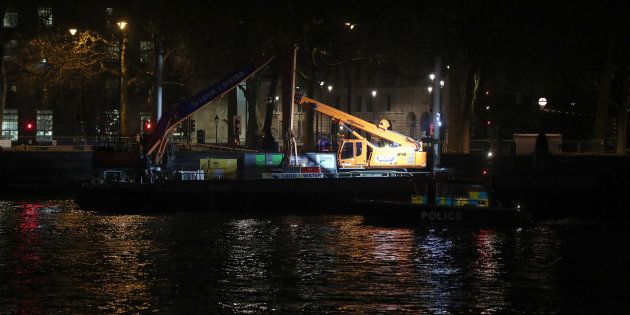 A police launch passes a barge moored on the River Thames in central London, as a suspected unexploded Second World War bomb has been found in the river, forcing the closure of Waterloo and Westminster bridges in London.
