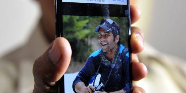 Alok Madasani's father holds up a smartphone with an image of his son at his residence in Hyderabad on Feb. 24, 2017.