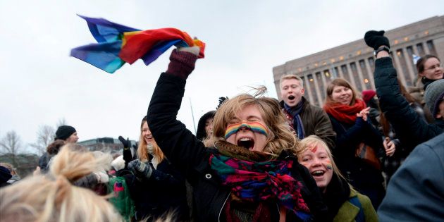 Supporters of same-sex marriage celebrate outside the Finnish Parliament in Helsinki November 28, 2014. The Finnish Parliament on Friday narrowly approved a citizen's initiative to legalise same-sex marriage. Gay couples in Finland have been able to enter into registered partnerships since 2002, but until now the country was the only one in the Nordic region to not allow same-sex marriage. Finland is now the 12th European state to do so. REUTERS/Mikko Stig/Lehtikuva (FINLAND - Tags: POLITICS) ATTENTION EDITORS - THIS IMAGE WAS PROVIDED BY A THIRD PARTY. FOR EDITORIAL USE ONLY. NOT FOR SALE FOR MARKETING OR ADVERTISING CAMPAIGNS. THIS PICTURE IS DISTRIBUTED EXACTLY AS RECEIVED BY REUTERS, AS A SERVICE TO CLIENTS. NO THIRD PARTY SALES. NOT FOR USE BY REUTERS THIRD PARTY DISTRIBUTORS. FINLAND OUT. NO COMMERCIAL OR EDITORIAL SALES IN FINLAND
