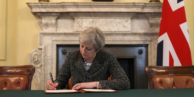 British Prime Minister Theresa May in the cabinet office signs the official letter to European Council President Donald Tusk invoking Article 50 and the United Kingdom's intention to leave the EU on March 28, 2017 in London, England. After holding a referendum in June 2016 the United Kingdom voted to leave the European Union, the signing of Article 50 now officially triggers that process. REUTERS/Christopher Furlong/Pool TPX IMAGES OF THE DAY