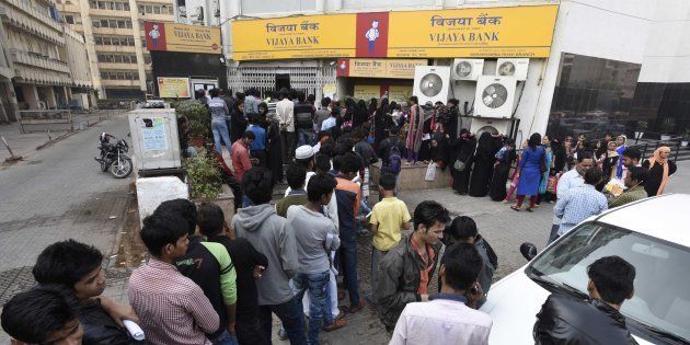NEW DELHI, INDIA - NOVEMBER 24: People stand in a queue outside banks to deposit and exchange old denomination Indian rupee 500 and 1000 currency notes, at Barakhamba Road, on November 24, 2016 in New Delhi, India.
