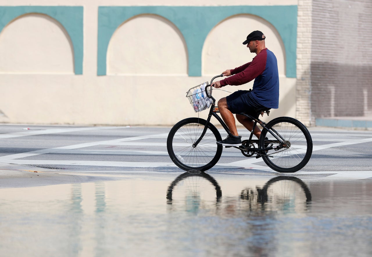 A cyclist in Miami rides past an area flooded during a king tide, an especially high tide, on Oct. 9, 2018.